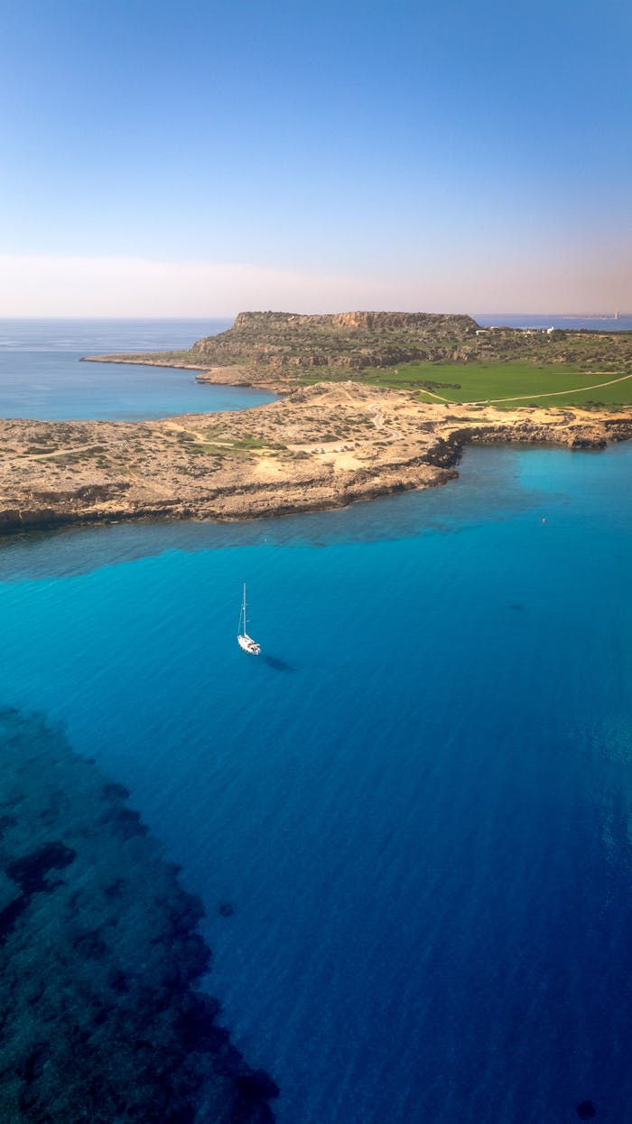 Explore the vibrant blue waters and rugged coastline of Cyprus with this breathtaking aerial view.